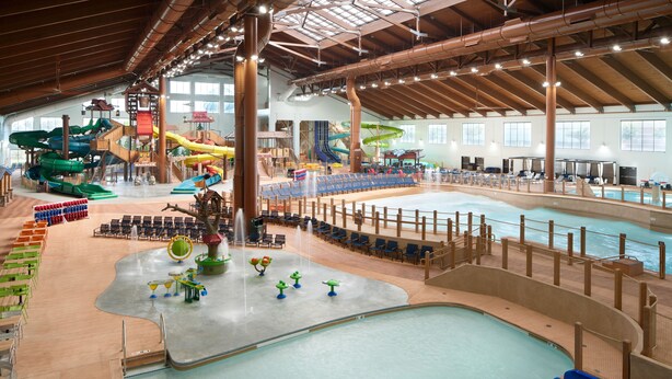 An indoor water park with multiple slides, a large pool, and seating areas. - Great Wolf Lodge Manteca (Manteca)