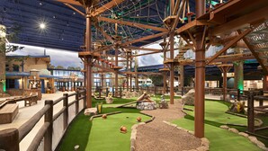 An indoor adventure park with rope bridges, artificial grass, and wooden structures. - Great Wolf Lodge Manteca (Manteca)