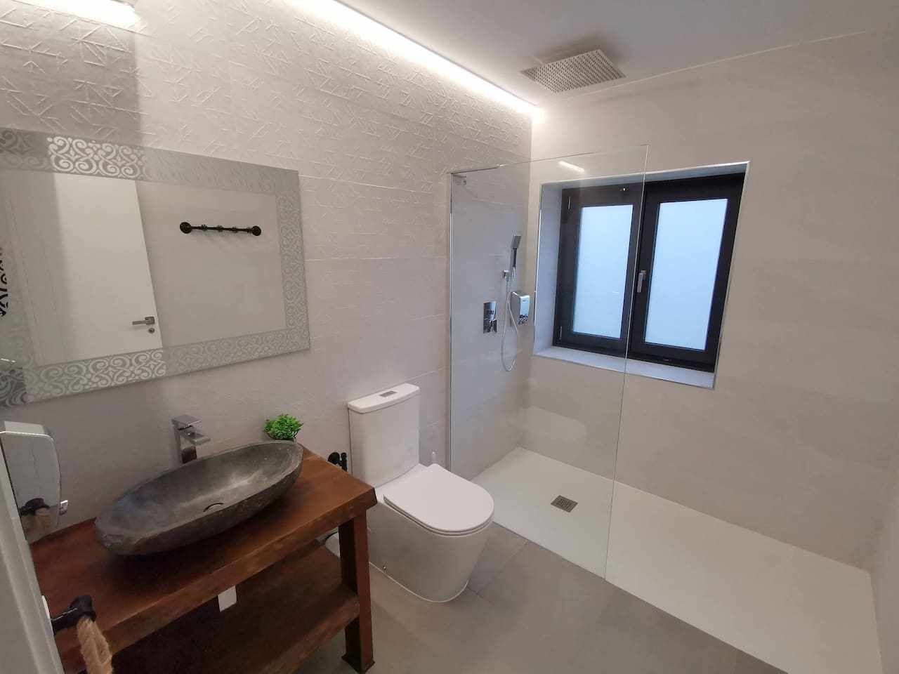 Une salle de bain moderne avec un grand lavabo sur pied, des toilettes et une douche.