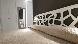 A bedroom with a bed, a wardrobe, and a mirror.