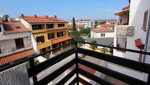 Un barrio residencial con edificios de varios pisos, balcones y un cielo despejado.