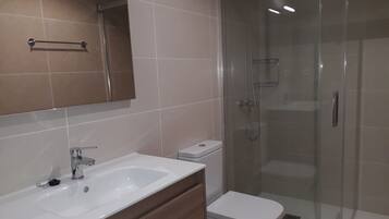 Regadera, secadora de cabello, toallas, papel de baño