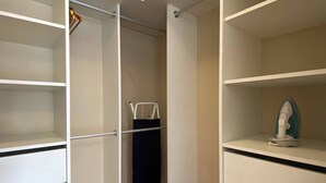 Un dressing avec des étagères ouvertes et une tringle pour suspendre les vêtements.