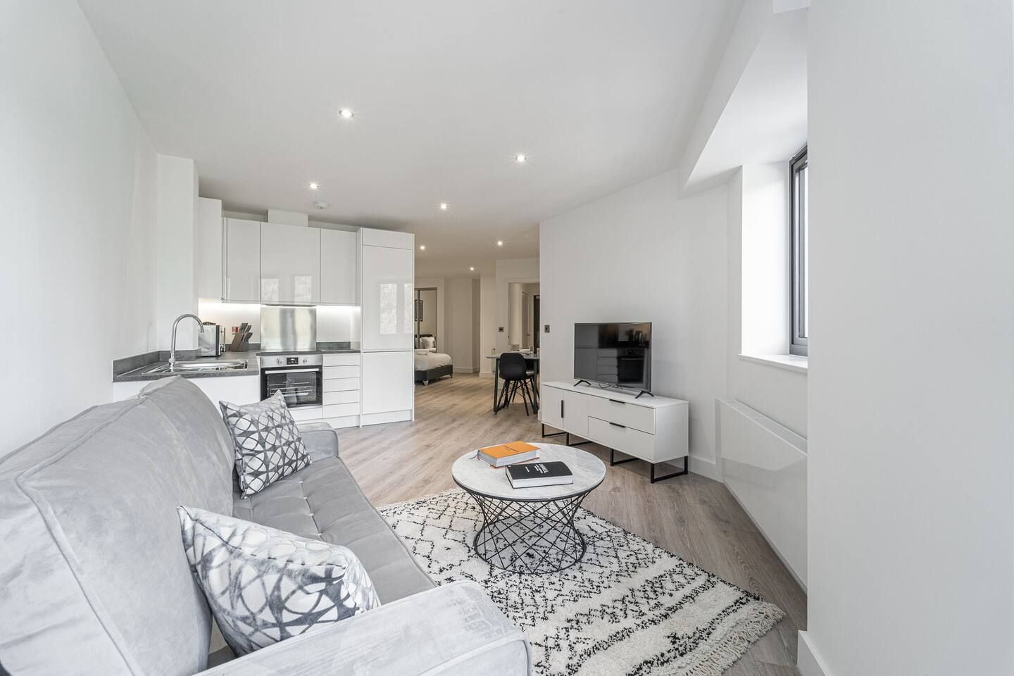 A modern apartment with a living room, kitchen, and dining area.