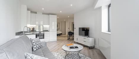 A modern apartment with a living room, kitchen, and dining area.
