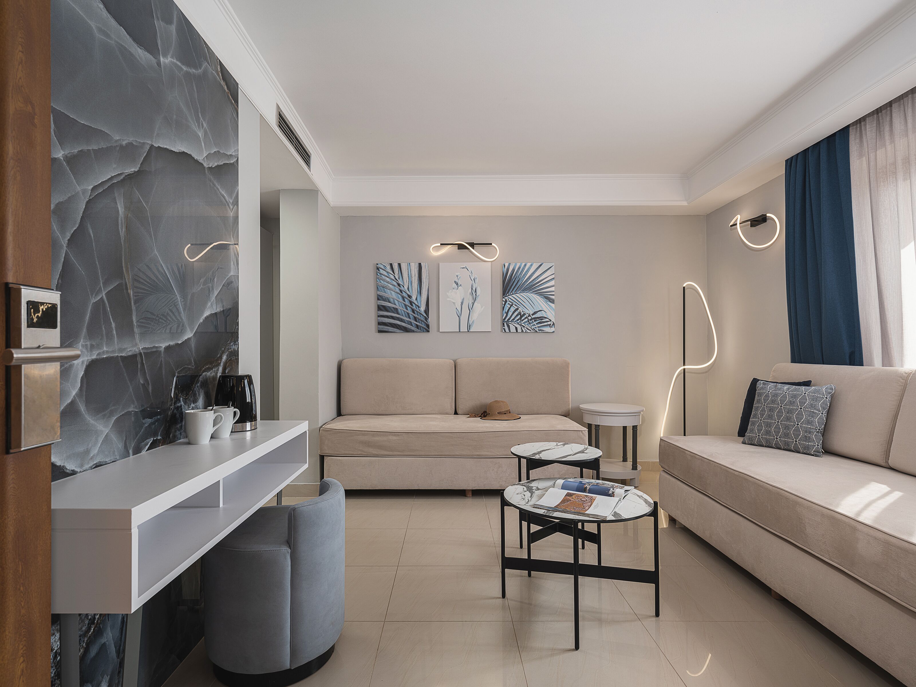 A modern living room with a sofa, a coffee table, and artwork on the wall.