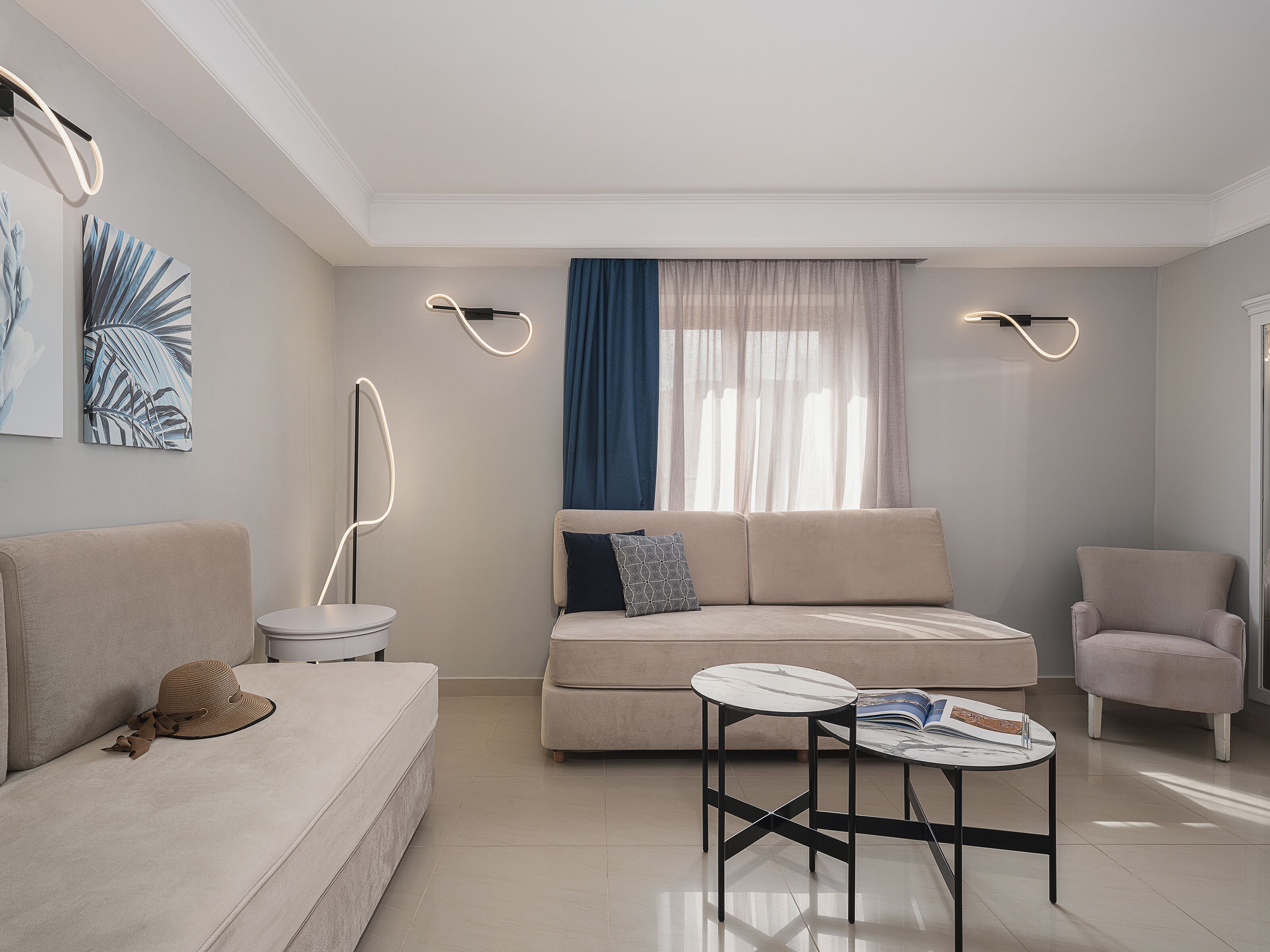 Uma sala de estar moderna com sofá, poltrona e mesa redonda.