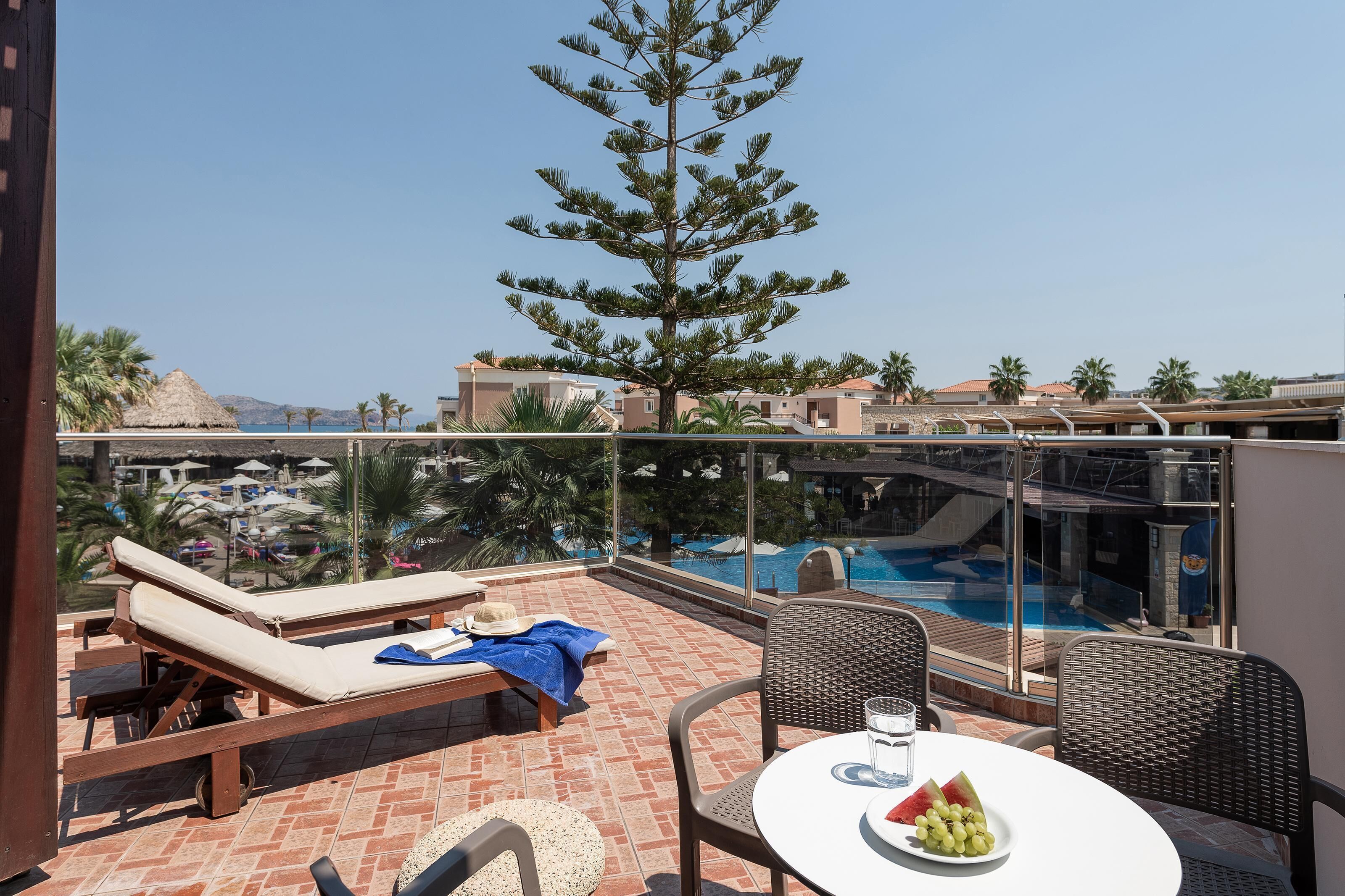 A rooftop terrace with a pool, lounge chairs, and dining table.