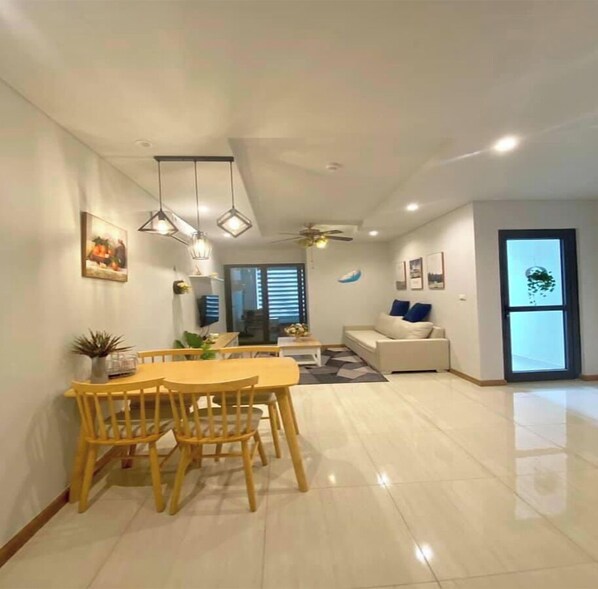 Relax in a spacious living area with a dining space, comfortable seating, and a large window offering a view of the outdoors.