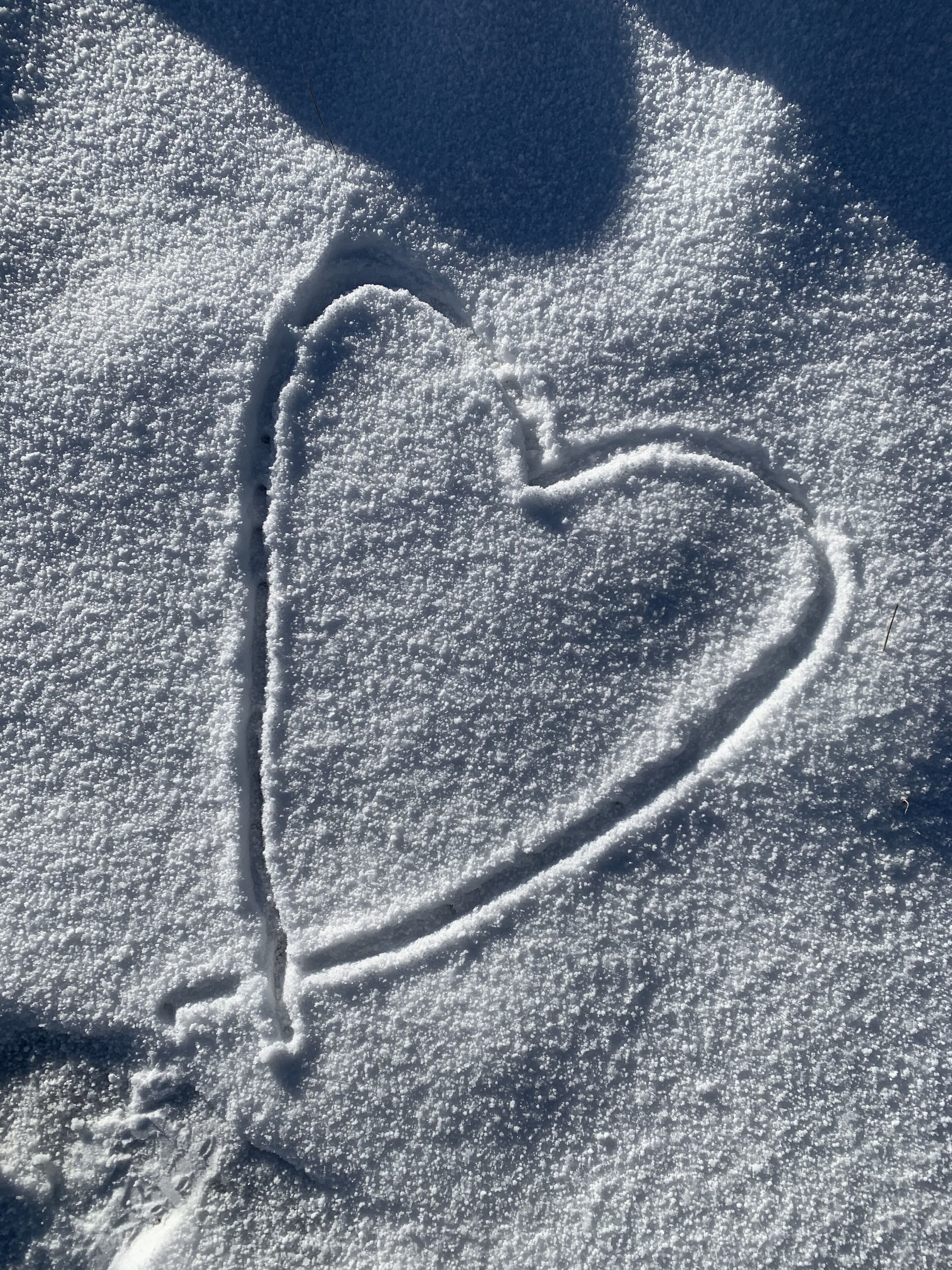 Een sneeuwpatroon in de vorm van een hart op een besneeuwd oppervlak.