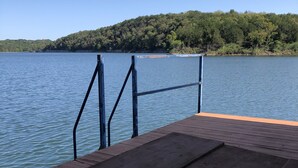 A wooden dock extending into a calm lake with a metal railing. - Lake front secluded house w/private boat/swim dock on 242 acre cattle ranch.  (Eagle Rock)
