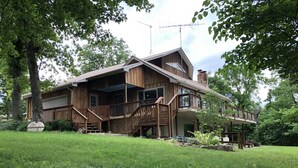 A two-story wooden house with a covered porch, a chimney, and a satellite dish. - Lake front secluded house w/private boat/swim dock on 242 acre cattle ranch.  (Eagle Rock)