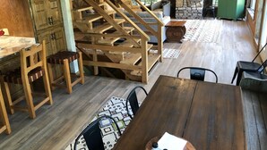 A spacious living area with a wooden staircase, a stone fireplace, and a green cabinet. - Lake front secluded house w/private boat/swim dock on 242 acre cattle ranch.  (Eagle Rock)