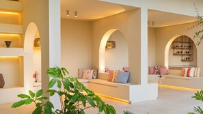 A modern interior with a central seating area, arched alcoves, and built-in shelving with decorative items.