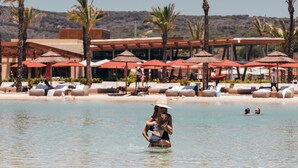 A pool area with lounge chairs and umbrellas, palm trees, and a building with a modern architectural style. - SO/ Sotogrande Spa and Golf Resort Hotel Costa del Sol (San Roque)