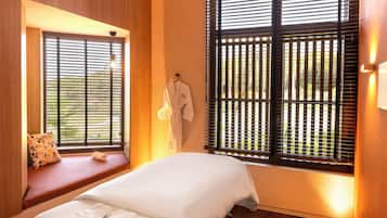Relax in a cozy space with a neatly made bed, comfortable seating area, and thoughtful amenities.