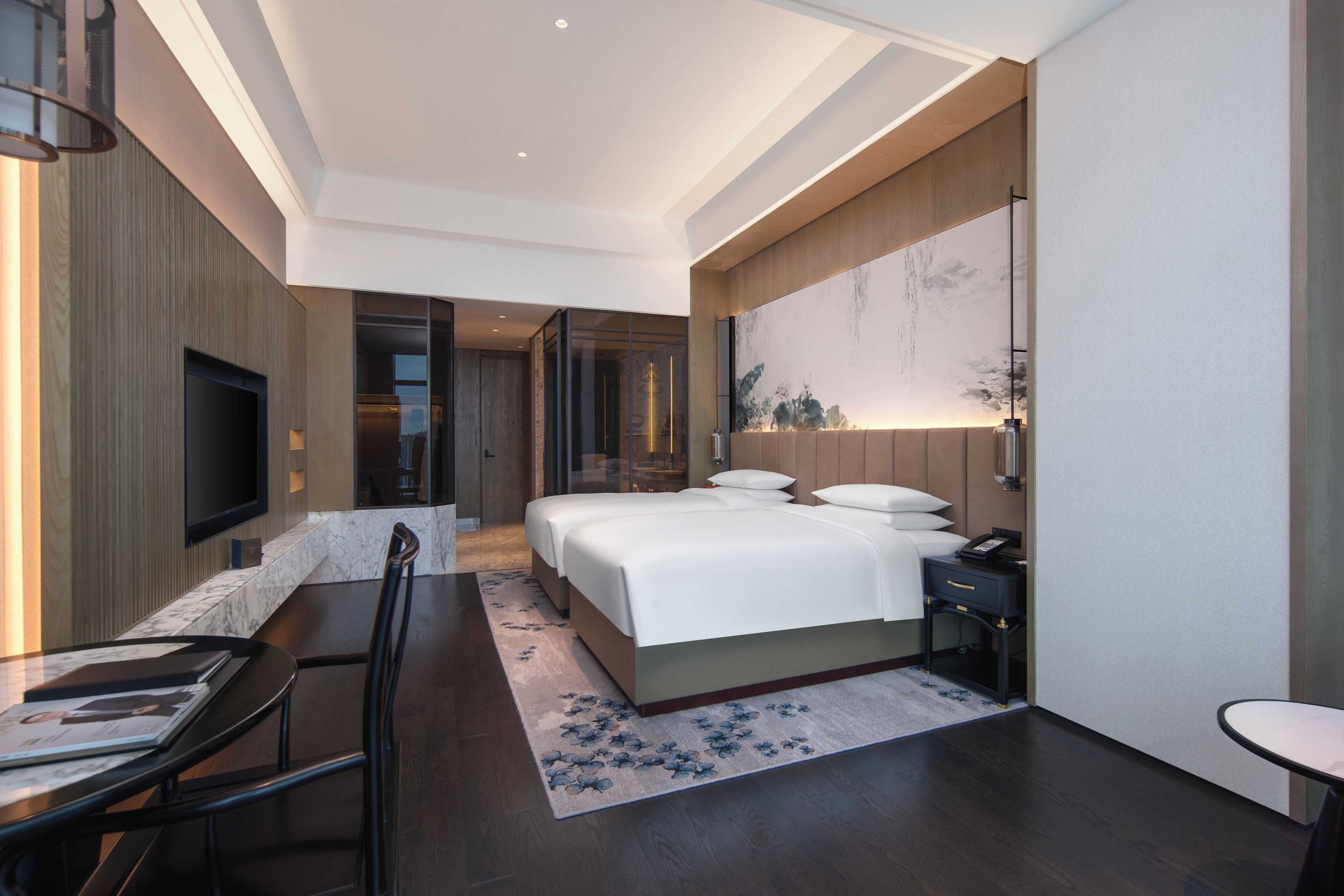 Una habitación de hotel moderna con una cama grande, un escritorio, una silla y un televisor.