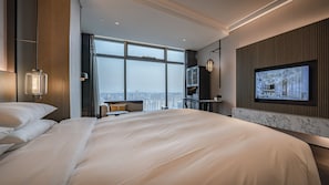 A modern hotel room with a large bed, a television, and a city view. - Sofitel Hangzhou Yingguan Hotel (Hangzhou)