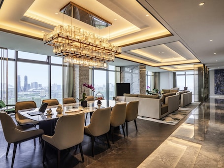 A modern hotel dining area with a large table, chairs, a chandelier, and a city view.. Sofitel Hangzhou Yingguan Hotel