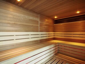 Uma sauna com bancos de madeira e paredes com ripas.