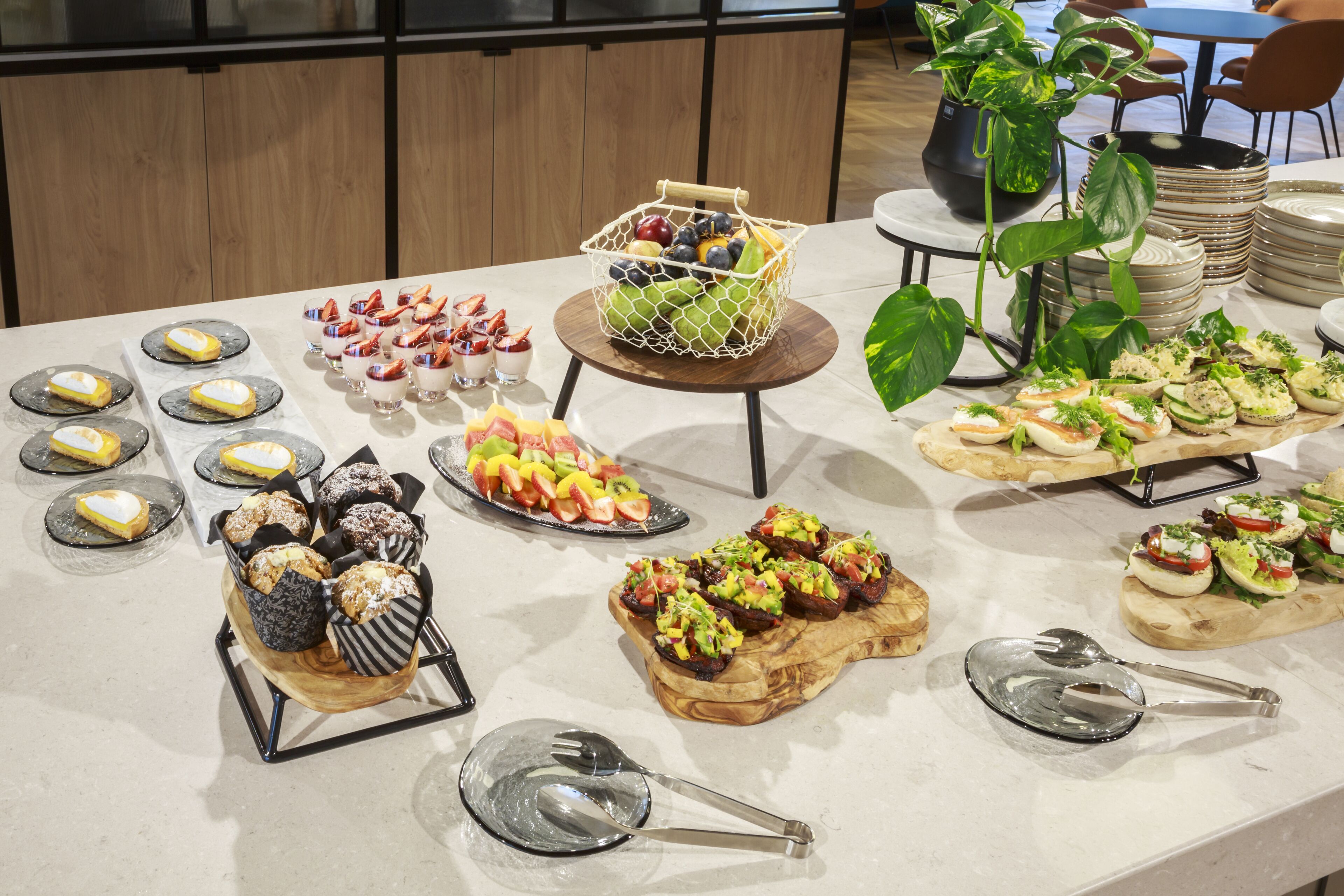 A buffet table with various food items and utensils.