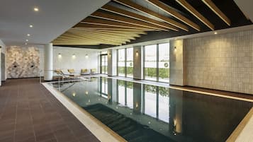 Una piscina techada, sillones reclinables de piscina
