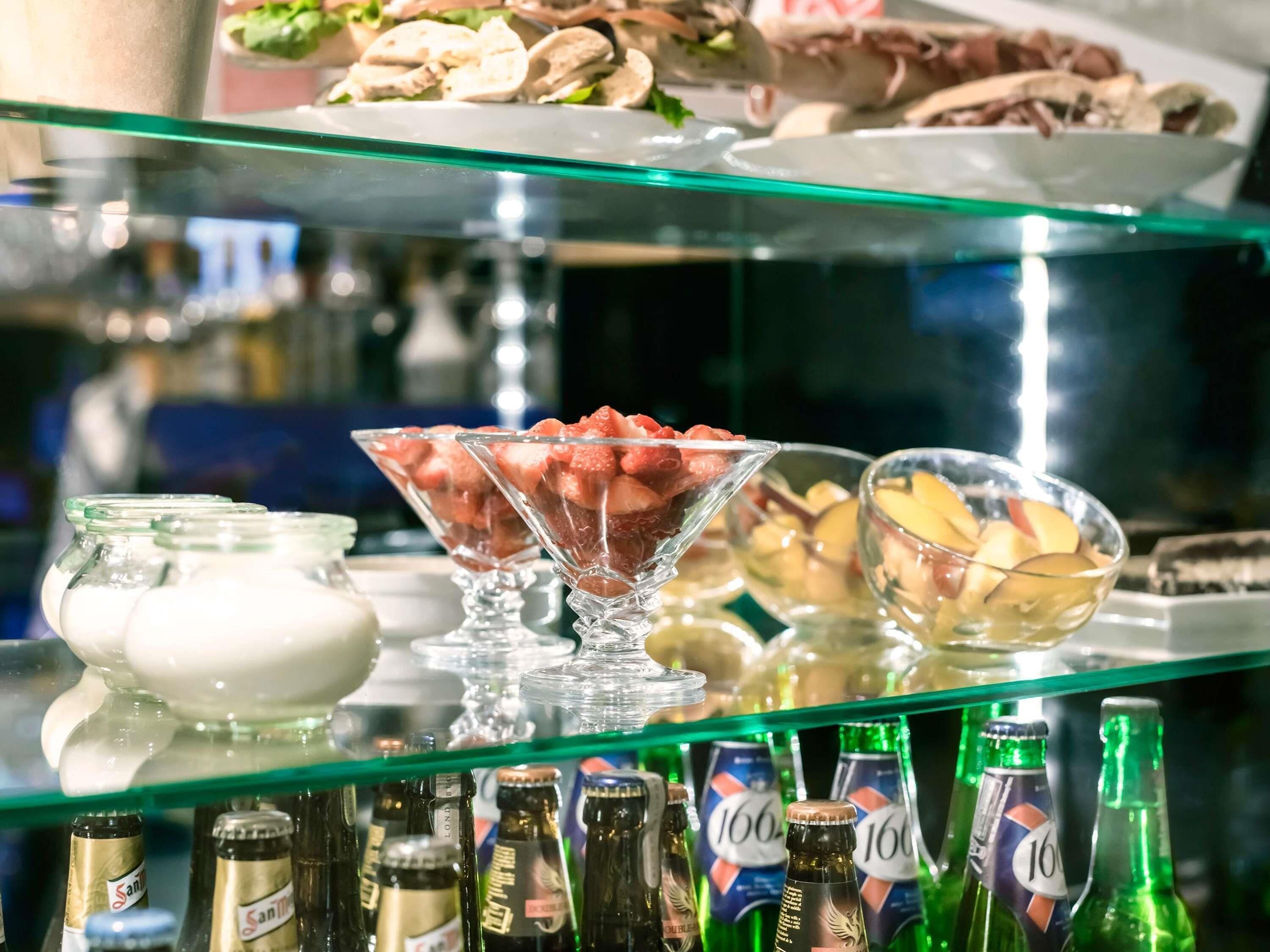 A buffet with various food items and bottles of beer.
