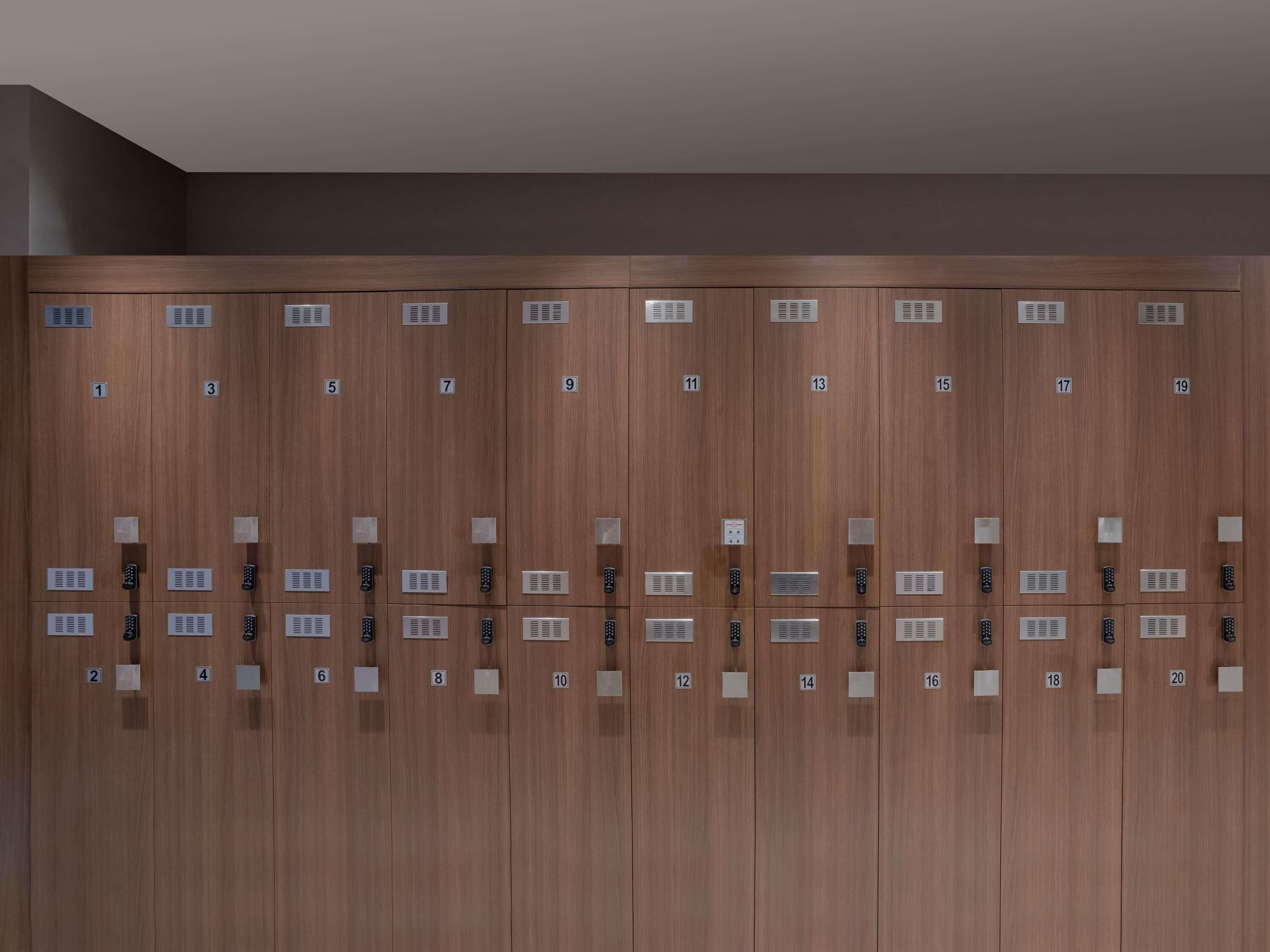 A row of wooden lockers with numbered compartments and electronic keypads.