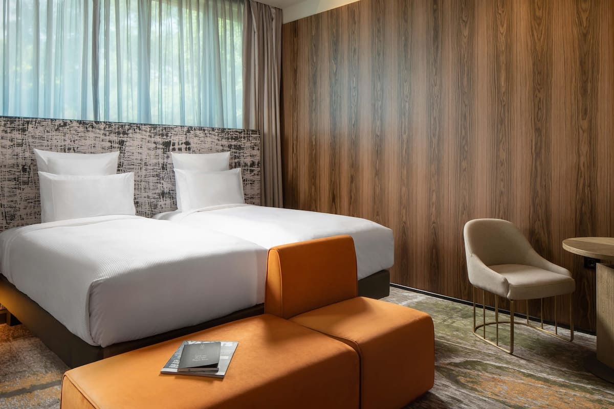 Una habitación de hotel con una cama grande, una mesita, una silla y un sofá.