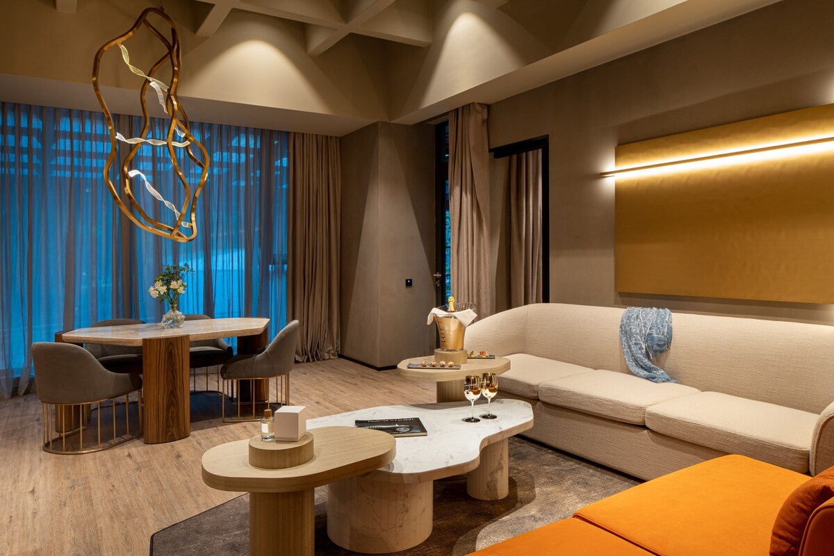 Ein modernes Wohnzimmer mit Esstisch aus Holz, einer Couch und einem Couchtisch.