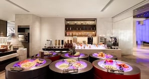 A modern hotel lobby with a self-service food station featuring various fruits and vegetables. - Novotel Shanghai Chuansha (Shanghai)