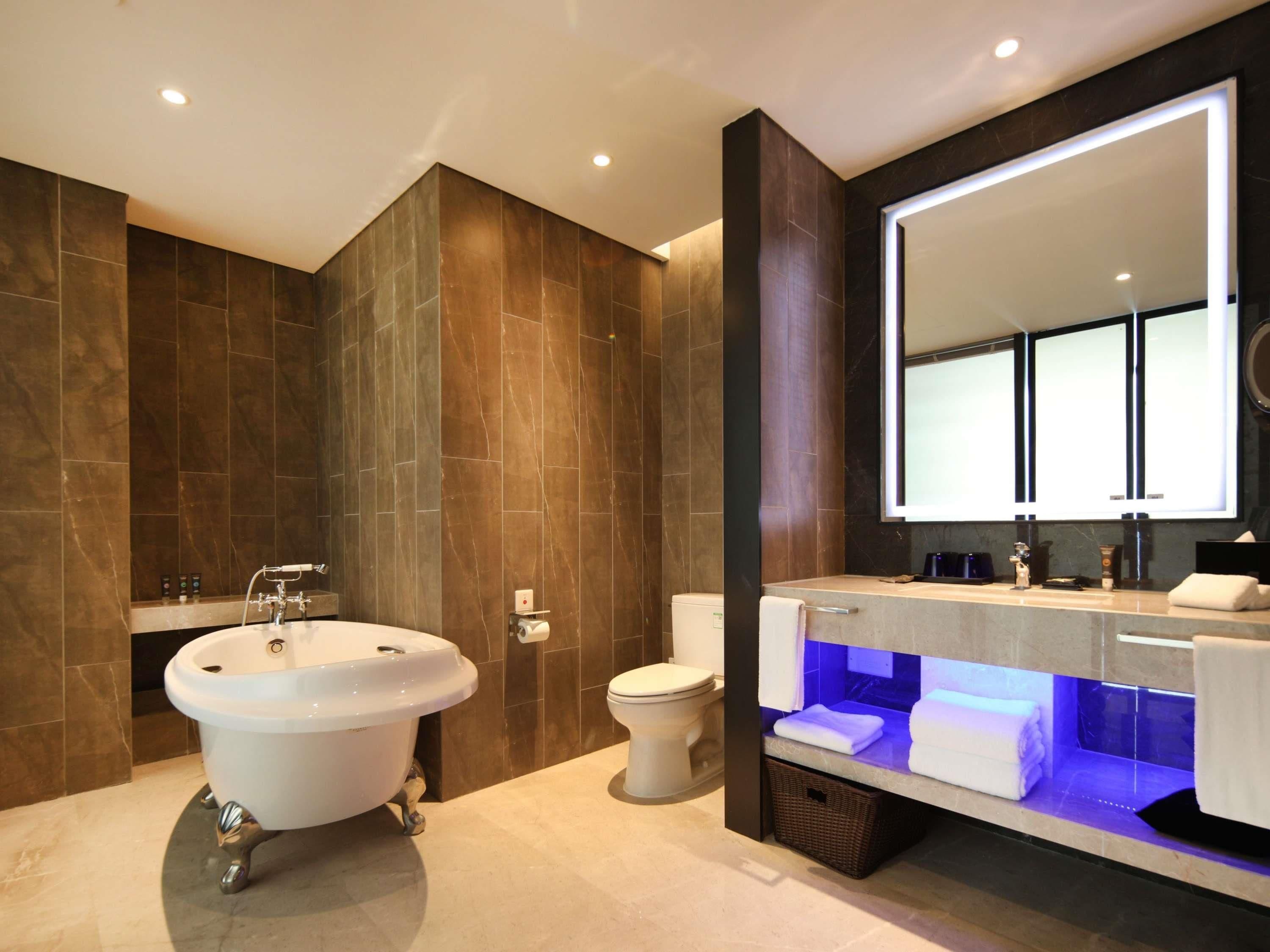 Un baño moderno con una bañera independiente, un inodoro y un tocador con espejo.
