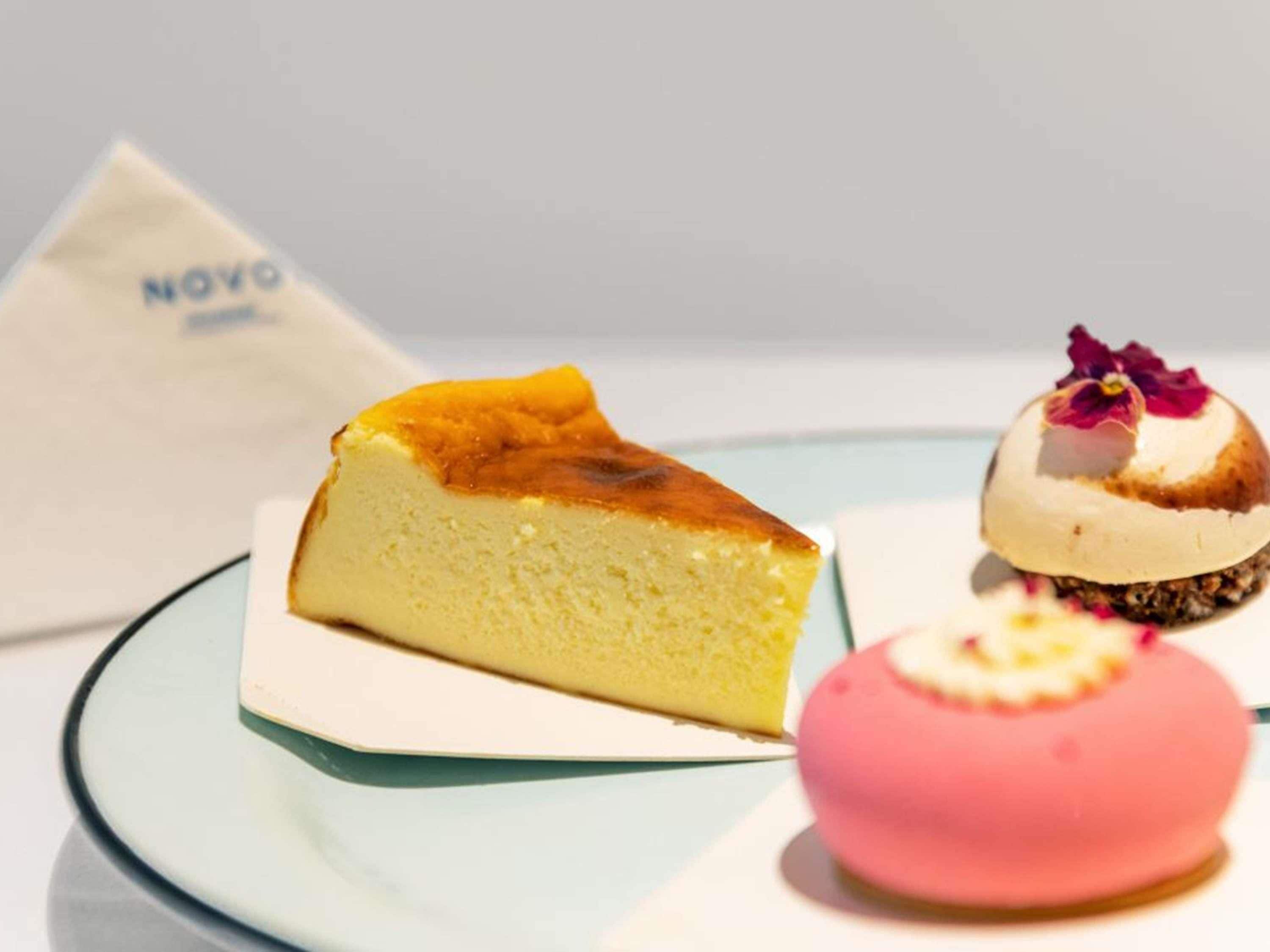 Ein Dessertteller mit einem Stück Käsekuchen und zwei weiteren Desserts.