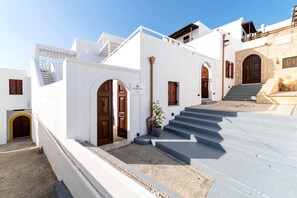 A white building with a staircase leading to a door marked 'LINDIAN POULS.'