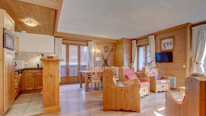 Ein Holzblockhaus-Innenraum mit Küche, Essbereich und Wohnzimmer.