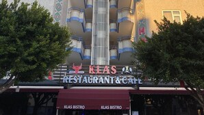 A hotel with a central elevator shaft, multiple balconies, and a restaurant and cafe at the ground level. - Suit Klas More Anex (Alanya)