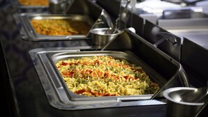 A buffet line with various dishes, including pasta and a casserole, in metal serving trays. - Suit Klas More Anex (Alanya)