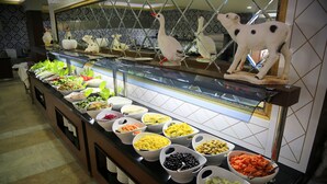 A buffet with various food options and decorative swans. - Suit Klas More Anex (Alanya)