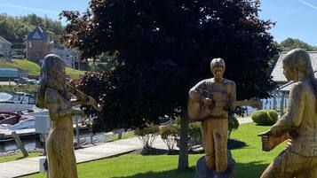 Outdoor wooden sculptures of musicians on tree stumps in a park.