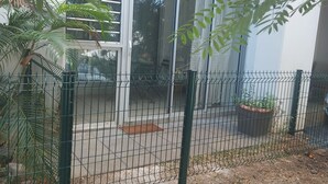 A modern building with large glass windows, a metal fence, and potted plants. - J&M'APART LOC SAISONNIERE SAINT GILLES LES BAINS (Saint Gilles Les Bains)