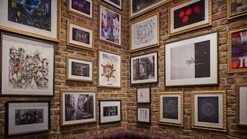 Een muur met verschillende ingelijste kunstwerken en een kamerbreed tapijt.