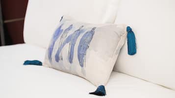 A pillow with tassels on a white sofa.