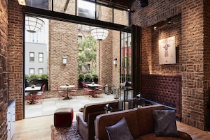 A cozy cafe with brick walls, red chairs, and a wooden bench.