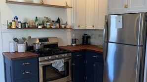 Keittiössä on tummansiniset kaapit, ruostumattomasta teräksestä valmistettu jääkaappi, liesi ja uuni. Liesen yläpuolella on hyllyjä, joilla säilytetään erilaisia keittiötarvikkeita.