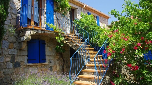 A stone building with blue shutters, a wooden staircase with blue railings, and a garden with pink flowers. - U Palmu, Sea 6 km, Panoramic view, Garden, Wifi, Air-conditioned (Sartène)