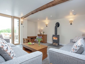 A cozy living room with a fireplace, sofas, a coffee table, and a dining area. - 3 bedroom accommodation in South Tawton, near Okehampton (South Tawton, near Okehampton)