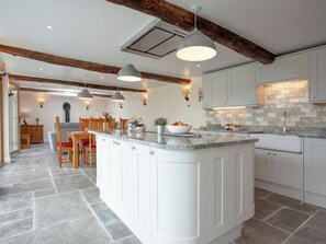 A modern kitchen with a central island, white cabinetry, and exposed wooden beams. - 3 bedroom accommodation in South Tawton, near Okehampton (South Tawton, near Okehampton)