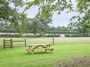 A picnic table in a grassy field with a wooden fence and trees in the background. - 3 bedroom accommodation in South Tawton, near Okehampton (South Tawton, near Okehampton)