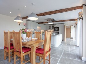 A modern kitchen with white cabinets, a central island, and wooden chairs with red cushions. - 3 bedroom accommodation in South Tawton, near Okehampton (South Tawton, near Okehampton)