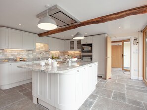 A modern kitchen with white cabinetry, a large island, and exposed wooden beams. - 3 bedroom accommodation in South Tawton, near Okehampton (South Tawton, near Okehampton)